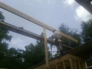 Carpenter setting a ridge beam over a new addition frame — Ice Dam Removal by Roofing Brothers in Canyon Country