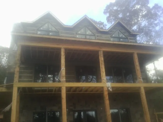 Dormers and porch framing on a large log home under construction — Roof Coating work by our crew in Canyon Country