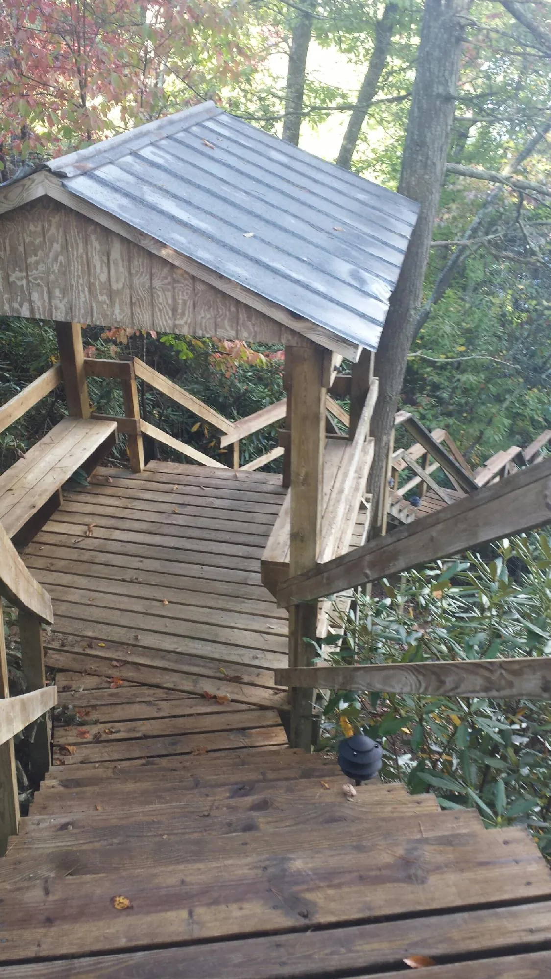Metal roofed shelter over wooden steps on a wooded walkway — Skylight Repair & Installation work by our crew in Canyon Country